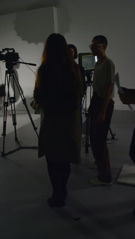 Vertical-Video-Of-Actors-Meeting-Female-Director-And-Crew-On-Film-Set-Shooting-Movie-Or-Video-In-Studio-1